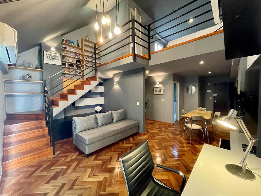 a living room with a couch and a staircase at Premium loft dúplex con terraza in Cordoba