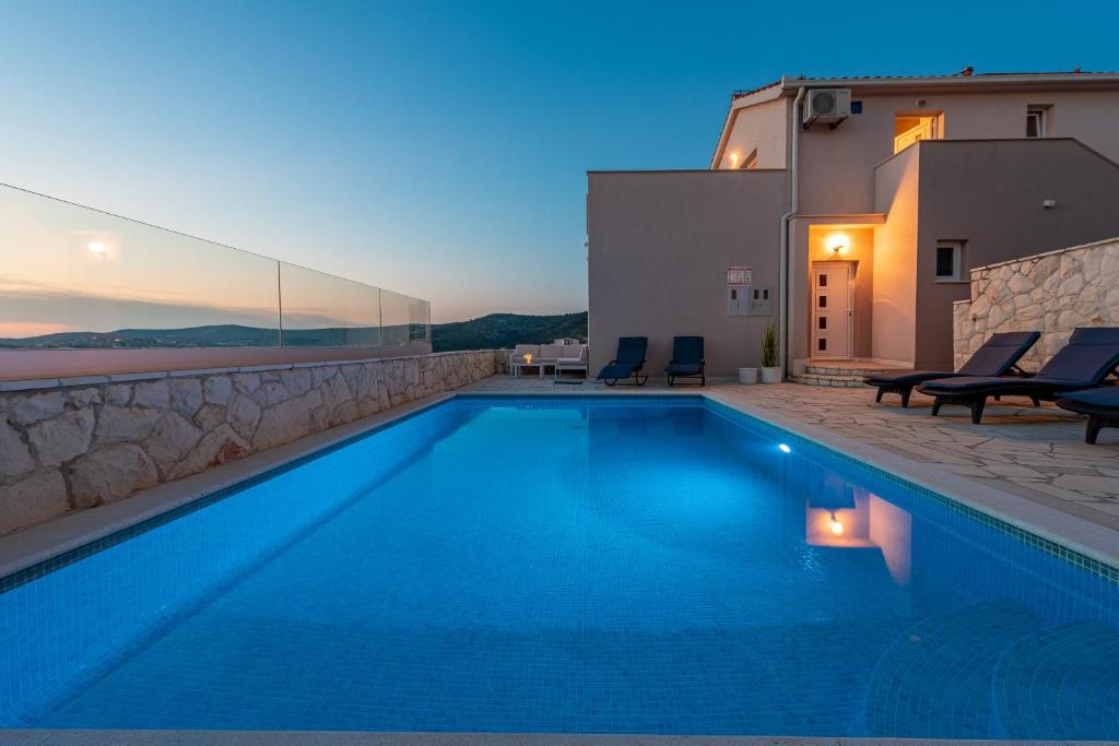 uma villa com piscina à noite em Villa Mona Apartments em Razanj