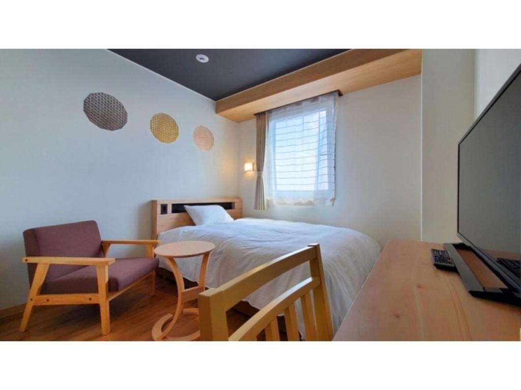 a bedroom with a bed and a desk and a television at ｂｕｓｉｎｅｓｓ&ａｃｔｉｖｉｔｙ ｃｈａｎｖｒｅ - Vacation STAY 64311v in Tochigi