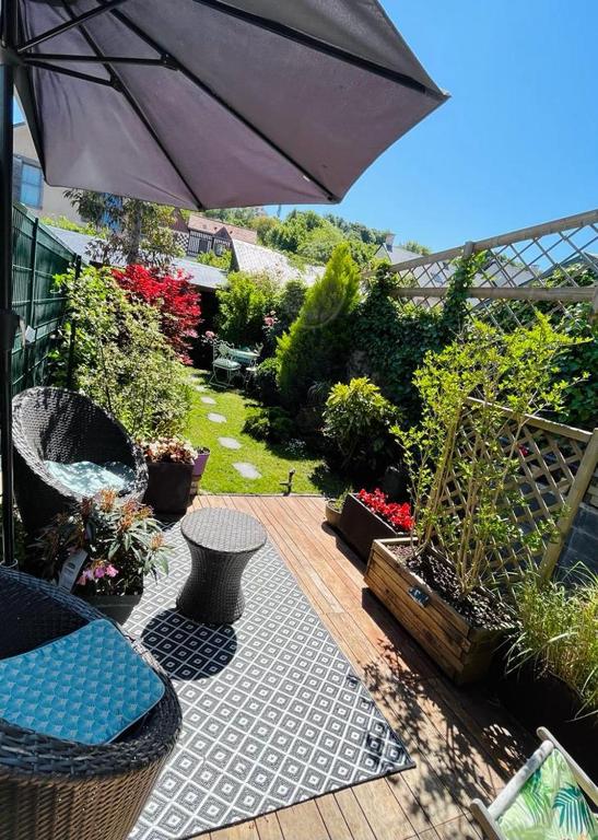a patio with an umbrella and some plants at Bienvenue chez Greg à Honfleur in Honfleur