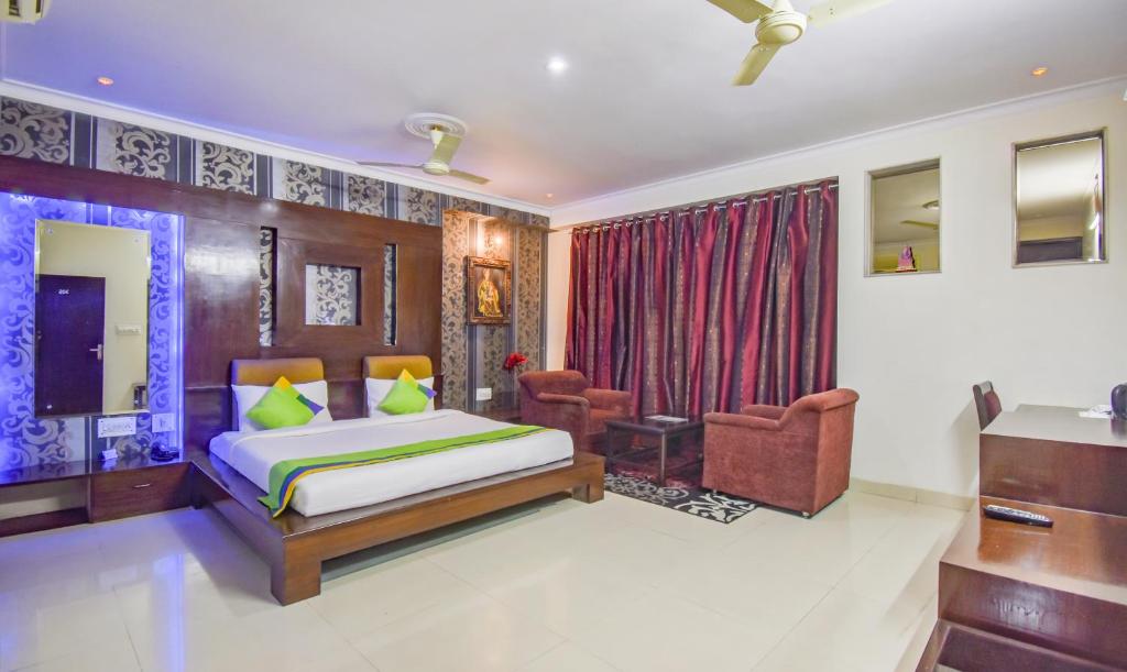 - une chambre avec un lit et une chaise dans l'établissement Treebo Trend Rockland And Restaurant, à Jaipur