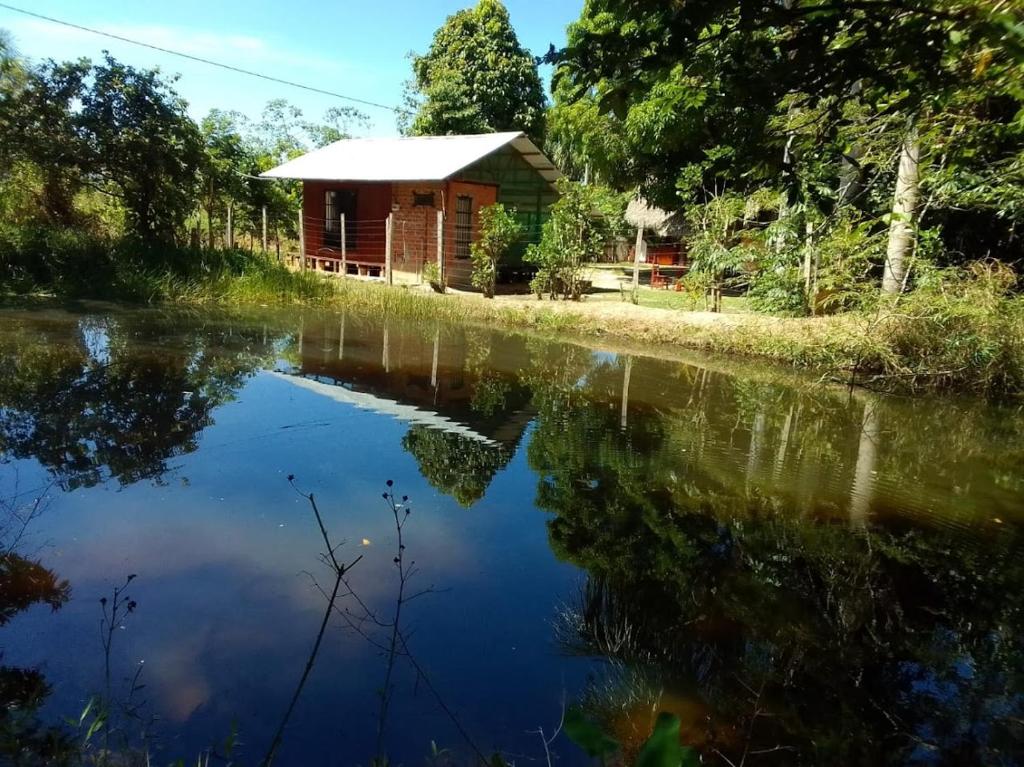 a cabin by a river with its reflection in the water at Albertico Jungle House in Pucallpa