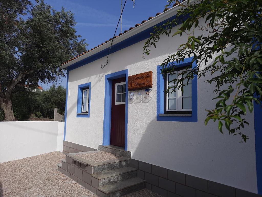 Casa azul y blanca con puerta y escaleras en Casinha das Oliveiras en Bugios