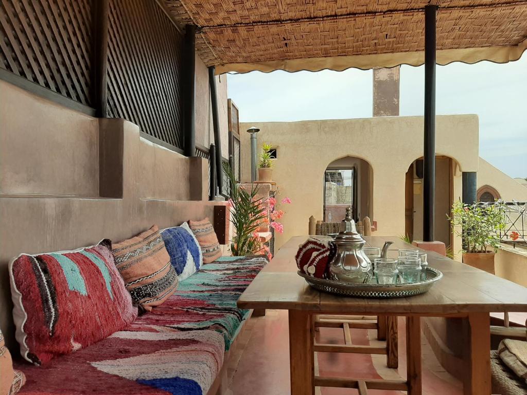 een patio met een tafel en kussens op een bank bij Riad Sabah in Marrakesh