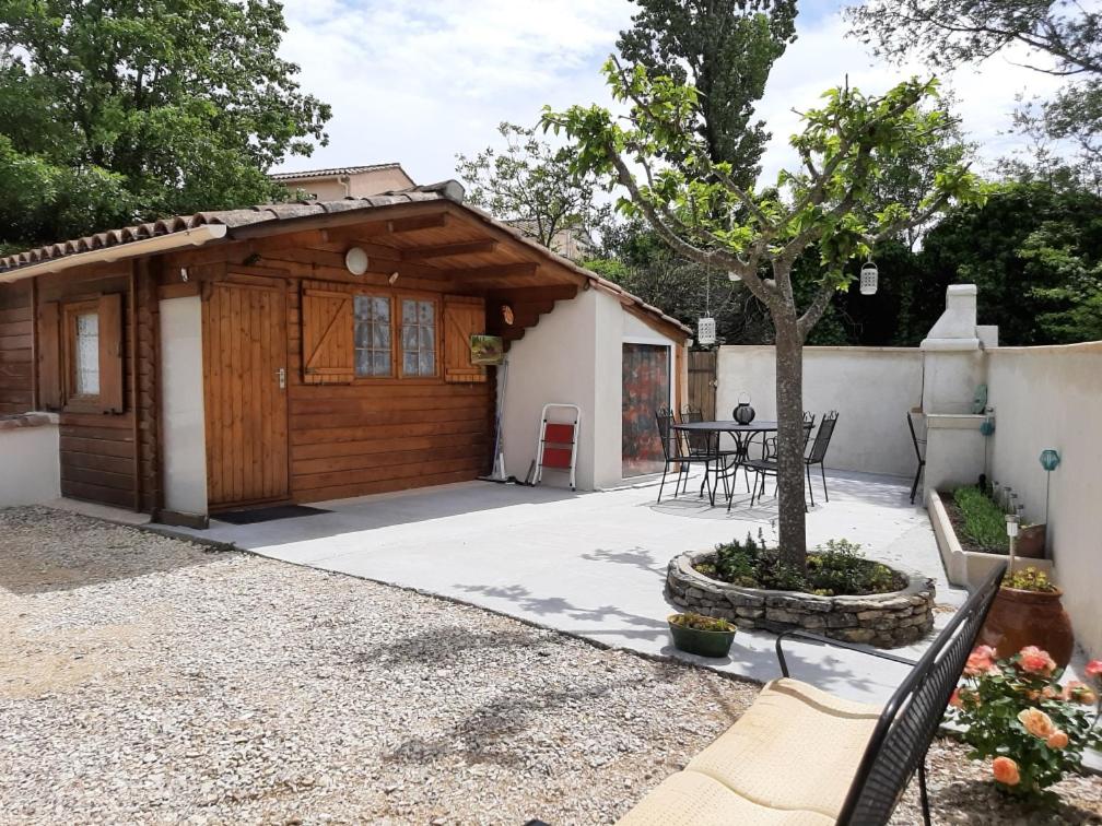 Casa con garaje de madera y mesa en Chalet au pied du Mont Ventoux, en Mormoiron