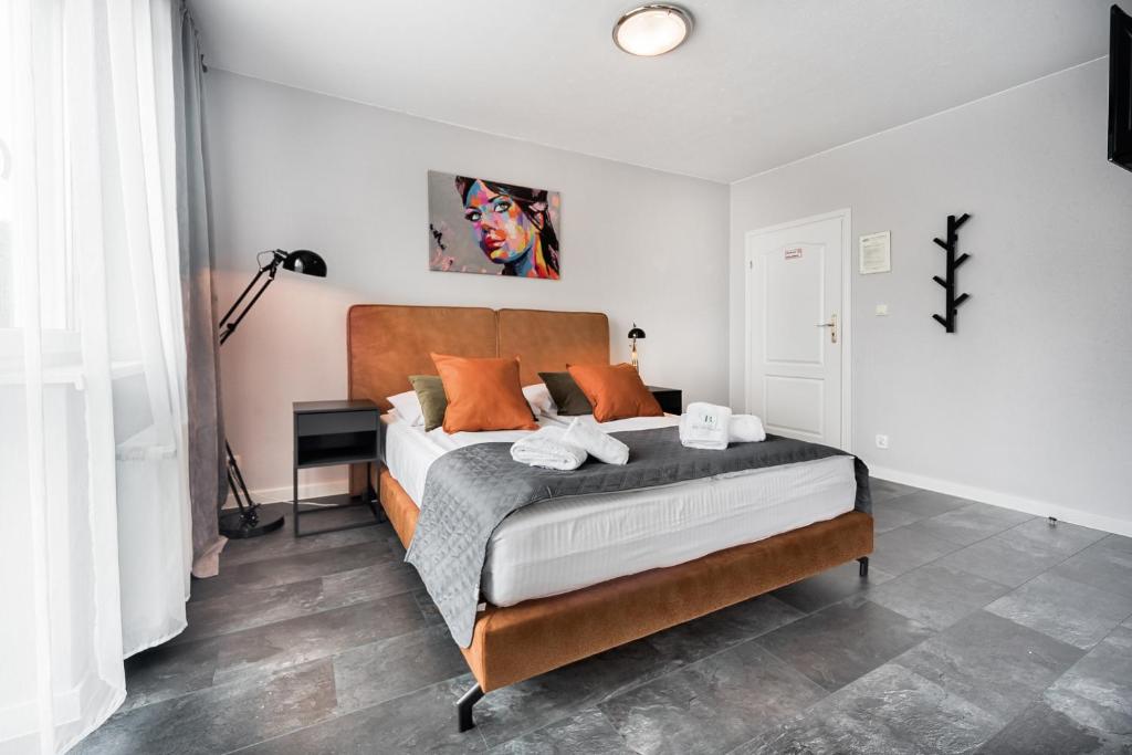 ミエンジズドロイェにあるVilla Bluemicaのベッドルーム1室(オレンジ色の枕が付いたベッド1台付)