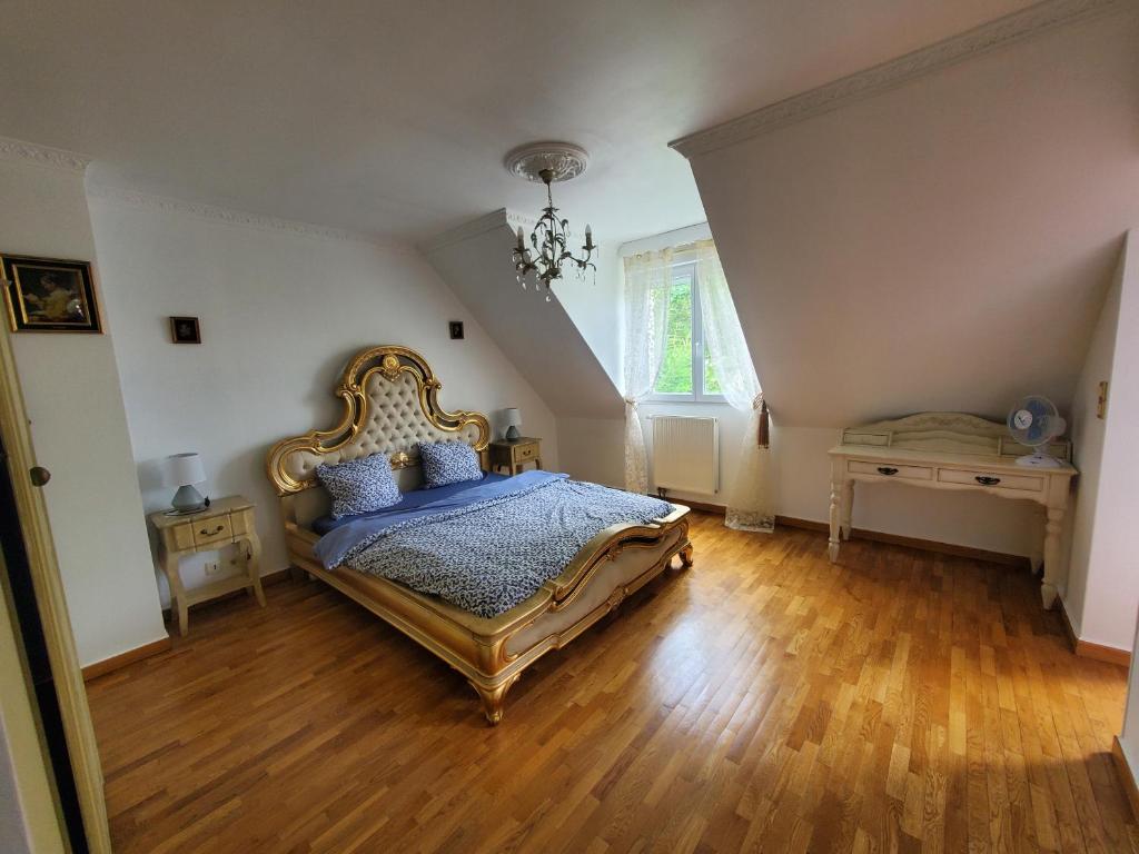 een slaapkamer met een kingsize bed en houten vloeren bij Hello Disneyland Paris in Bussy-Saint-Georges