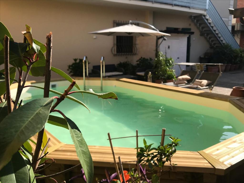 einen Pool mit einer Holzterrasse neben einem Haus in der Unterkunft Il Fiordaliso in Massa e Cozzile