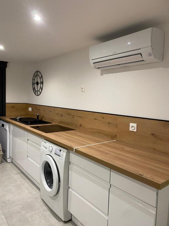 a kitchen with a washer and a sink and a stove at Au soleil in Canet-en-Roussillon