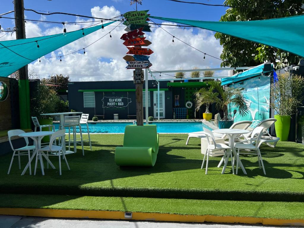 a group of tables and chairs next to a pool at Nomada Beach Hostel- Isla Verde in San Juan