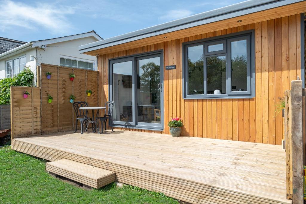 een houten terras aan de zijkant van een huis bij The Jolly Lodge-Sea Views-Free Parking in Lyme Regis