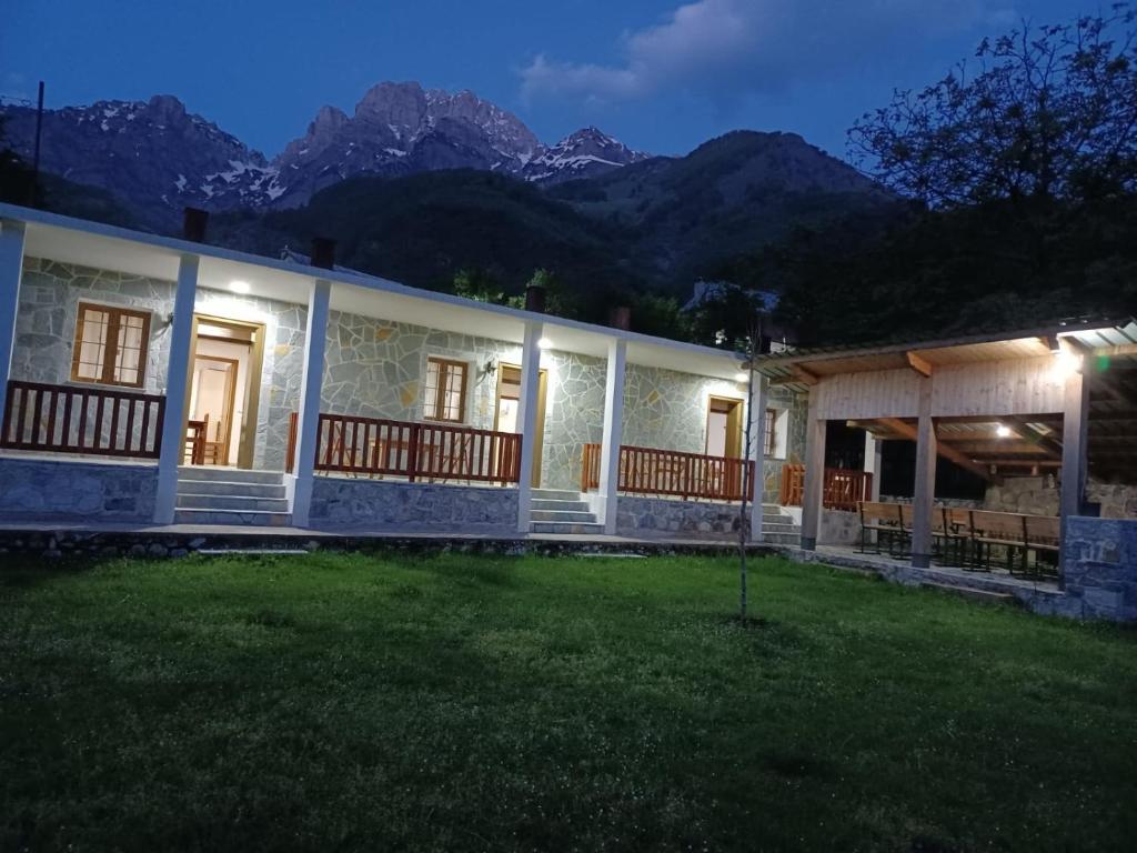 una casa con vistas a las montañas por la noche en Buni Shqipes, en Theth