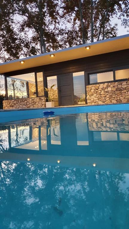 a house with a swimming pool in front of it at Casa de Piedra in Zonda