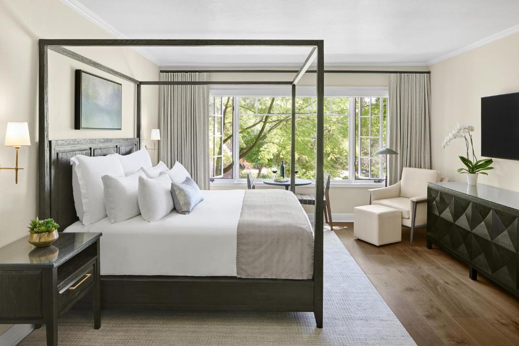 a bedroom with a large white bed and a desk and a window at Milliken Creek Inn in Napa