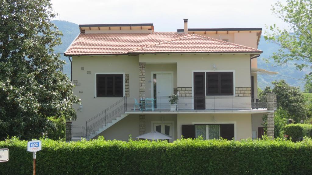 ein großes weißes Haus mit Balkon oben in der Unterkunft Casa Vacanze “Bouganville” loc Avane Pisa in Vecchiano