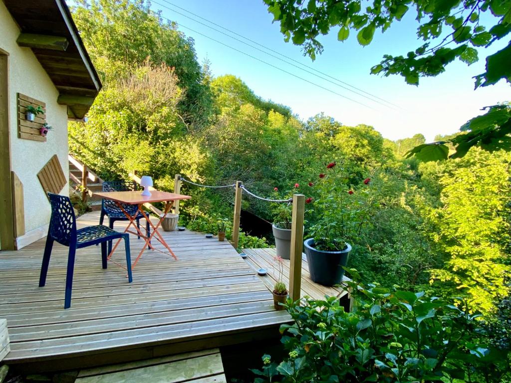 una terraza de madera con mesa y sillas. en la chambre d hotes de marie indépendante et sa terrasse avec vue panoramique proche alpes mancelles, en Sillé-le-Guillaume