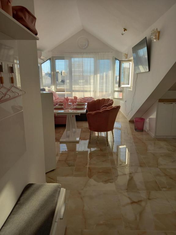 a living room with a staircase and a table and chairs at Perla 2 studio in Burgas City