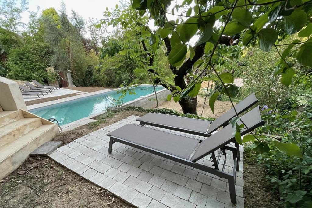a bench sitting next to a swimming pool at Maison & Jardin Coeur Luberon classé 4 étoiles in Peypin-dʼAigues