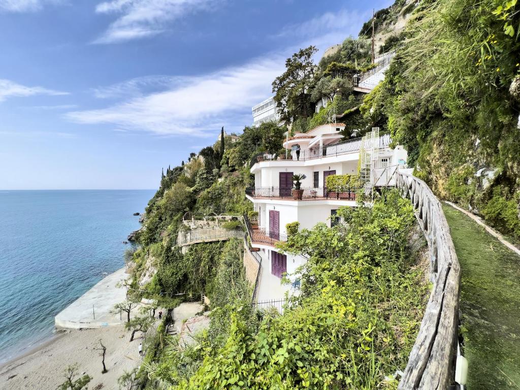 a building on a cliff next to the ocean at Due Relais - Panoramic Sea View Suites in Vietri sul Mare