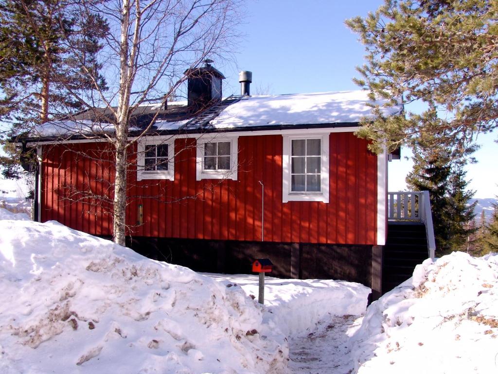 a red house with snow in front of it at Holiday Home Långberget in Sysslebäck