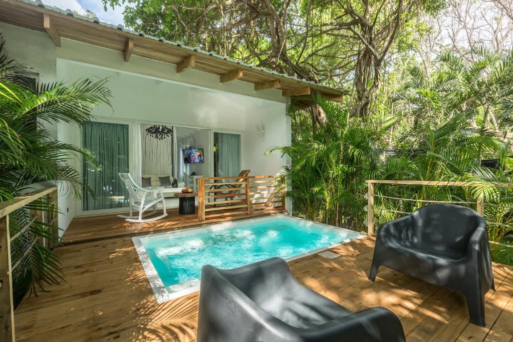 a patio with a swimming pool and chairs and a house at Gigi Brown Beachfront Santa Teresa in Santa Teresa Beach