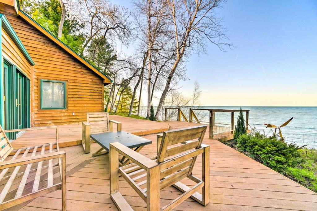 a wooden deck with two benches and a table at Lakefront Applegate Retreat with Private Beach! in Applegate
