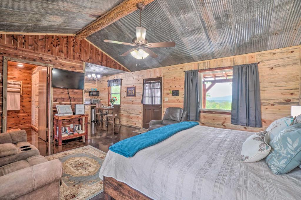 Schlafzimmer mit einem Bett und einem Deckenventilator in der Unterkunft Updated Studio Cabin in Ozark - Mountain View in Ozark