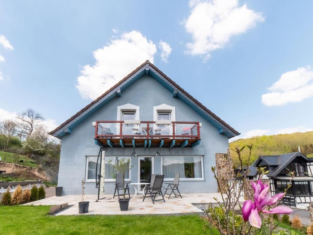 a blue house with a balcony on the front of it at Large holiday home in Mimbach with private garden in Ditscheid