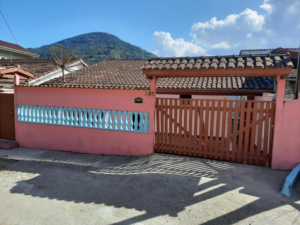 a gate to a house with a mountain in the background at Casa Ednalda in Ubatuba