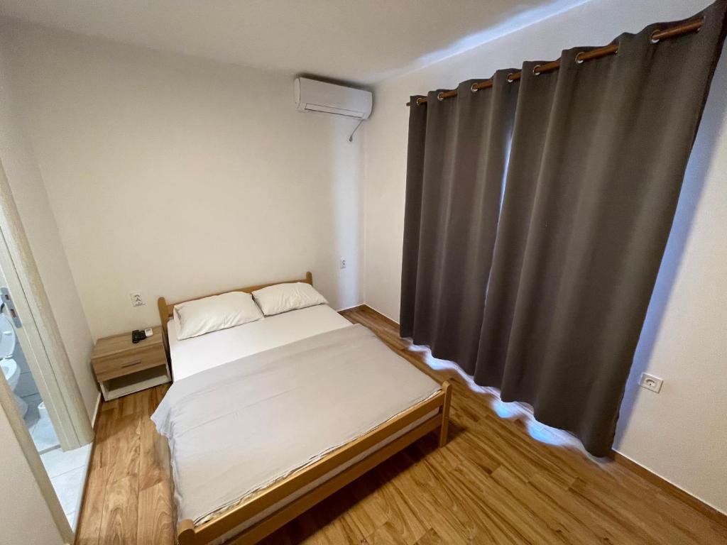 a small bedroom with a bed and a curtain at Apartments Dionis in Kotor