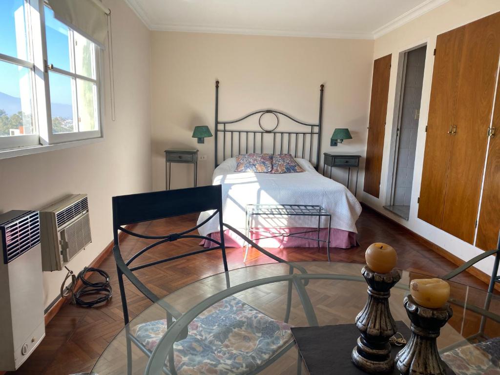 Un dormitorio con una cama y una mesa de cristal. en Departamento Mayoral, en Salta