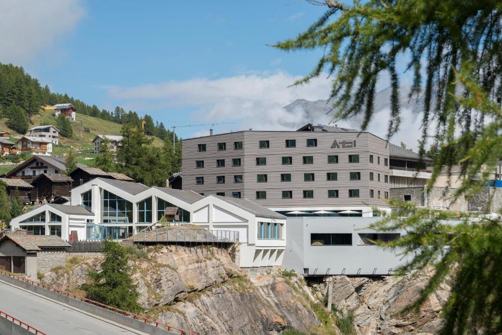 ein Gebäude auf einem Hügel mit Häusern in der Unterkunft wellnessHostel4000 in Saas-Fee