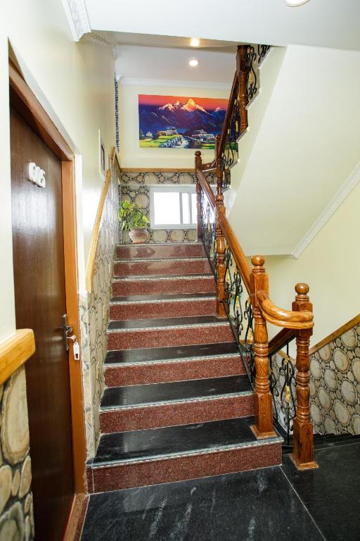 a staircase in a home with a wooden railing at Gauri Shankar Hotel Nagarkot in Nagarkot