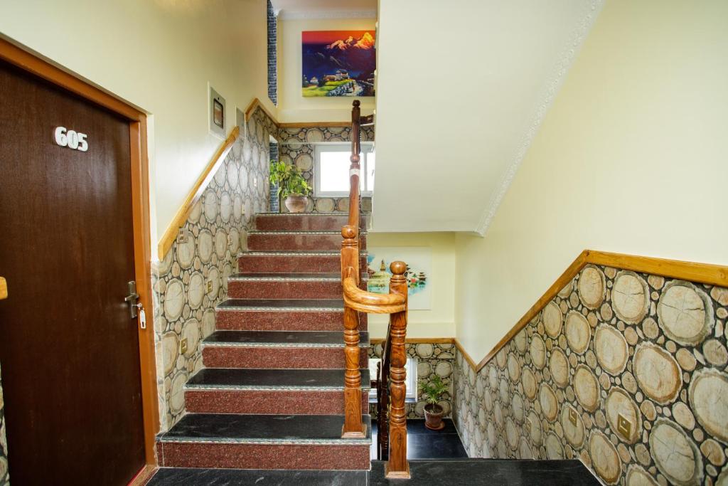 a staircase in a house with a wooden door at Gauri Shankar Hotel Nagarkot in Nagarkot