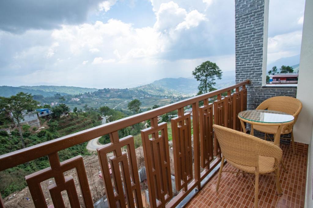 balcón con mesa, sillas y vistas en Gauri Shankar Hotel Nagarkot, en Nagarkot