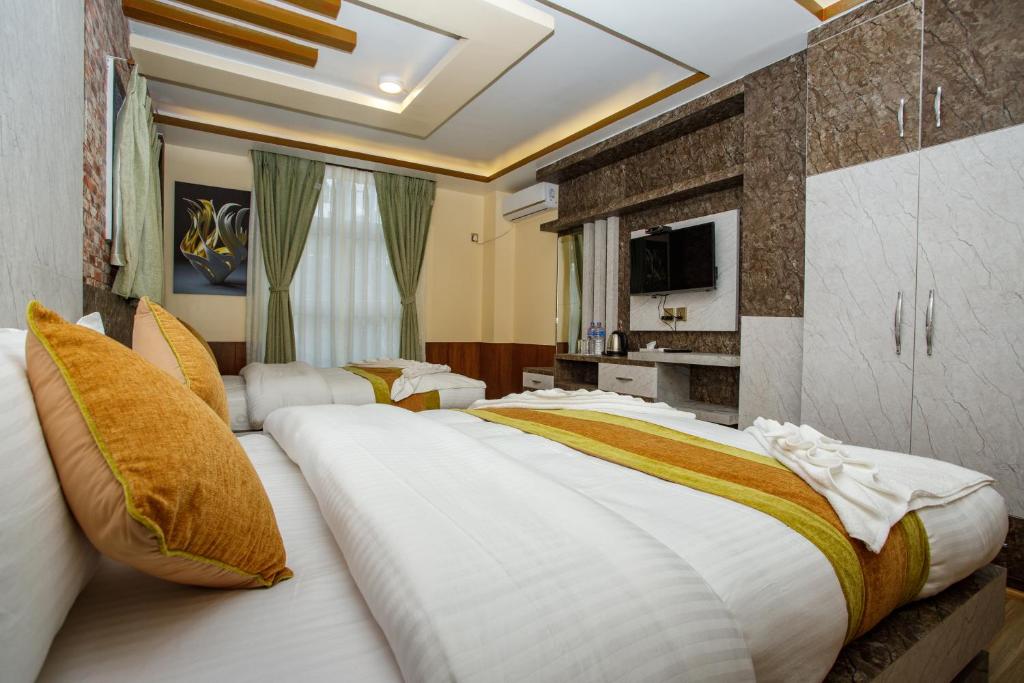 a hotel room with two beds and a tv at Gauri Shankar Hotel Nagarkot in Nagarkot