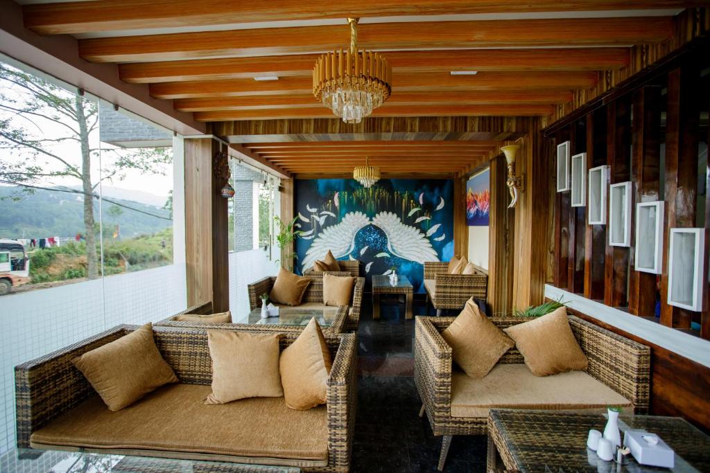 a patio with couches and tables and a chandelier at Gauri Shankar Hotel Nagarkot in Nagarkot