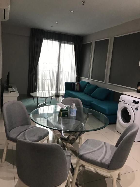 a living room with a glass table and chairs at Homestay Muslim I-City Shah Alam in Shah Alam
