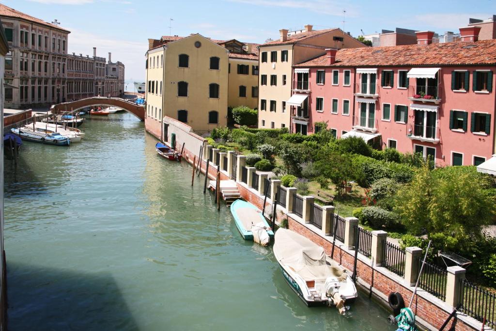 a view of a river with boats in a city at Hotel Giudecca Venezia in Venice