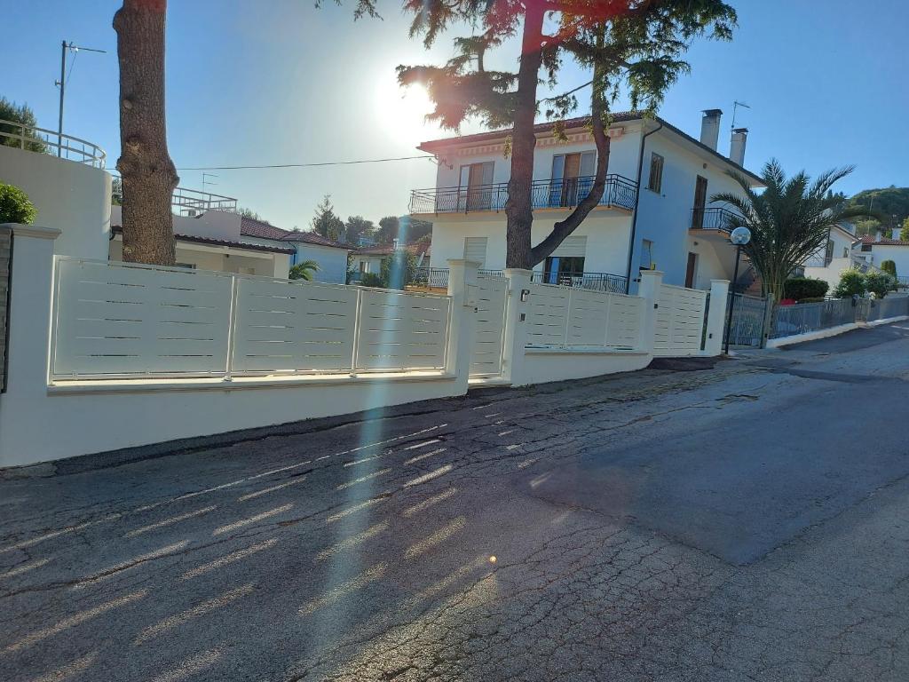 uma cerca branca no lado de uma rua em Villa Virlan em Numana