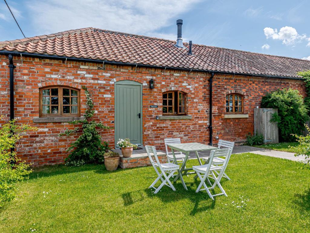 a table and chairs in front of a brick house at Barn End in Lincoln