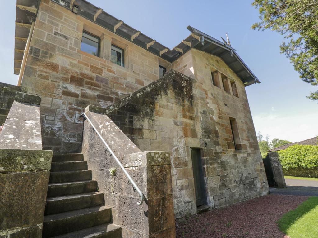 un ancien bâtiment en pierre avec des escaliers menant à celui-ci. dans l'établissement The Coach House - Holmwood, à Glasgow