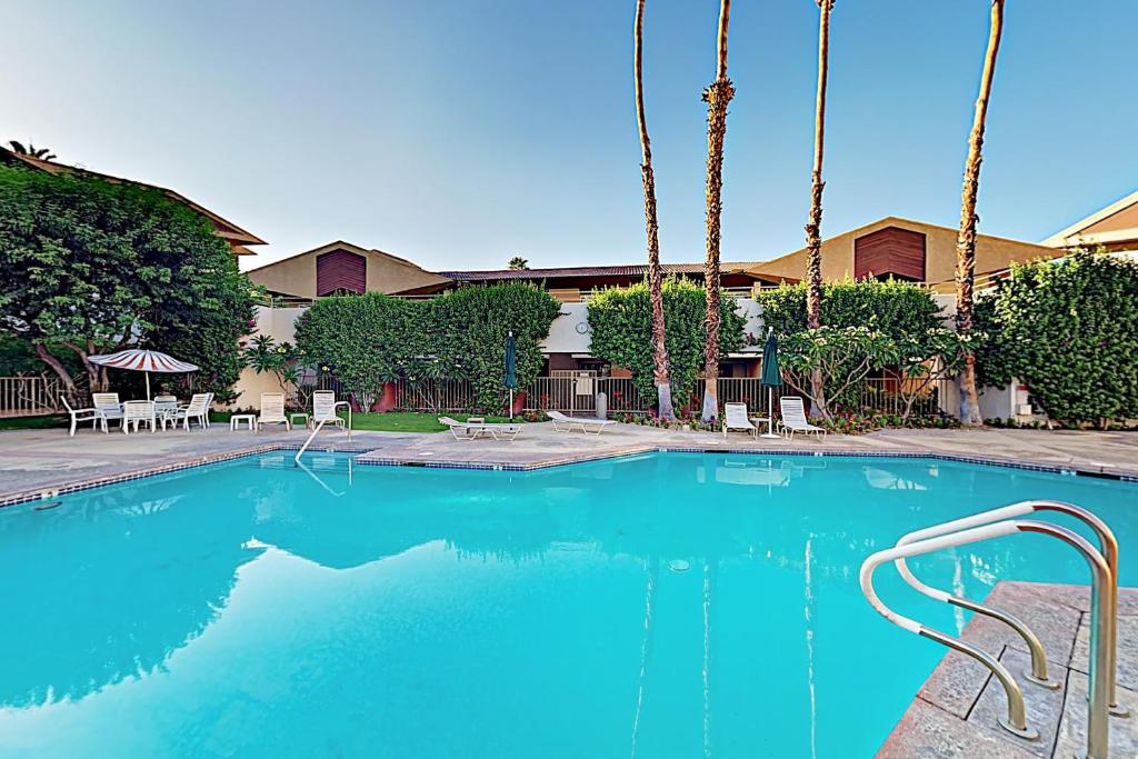 - une piscine d'eau bleue en face d'un bâtiment dans l'établissement Biarrtx D20, à Palm Springs