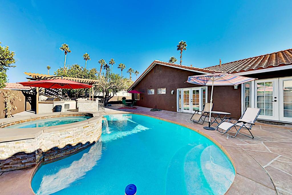 een zwembad met twee stoelen en een huis bij Calle Quito Escape Permit# 217,228 in La Quinta