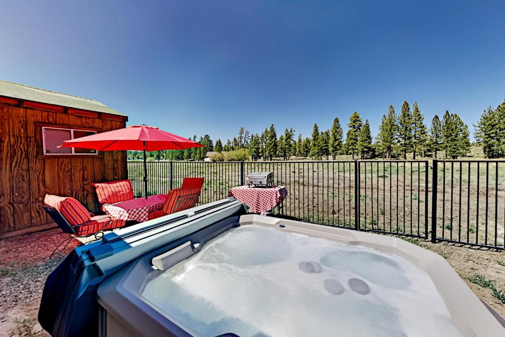 bañera de hidromasaje con 2 sillas y sombrilla en Meadow-Front Metcalf Bay Gem, en Big Bear Lake