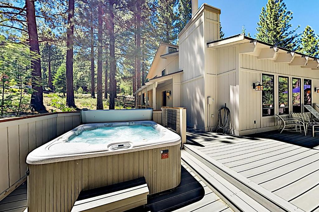 a hot tub sitting on a deck next to a house at Northstar Home in Truckee