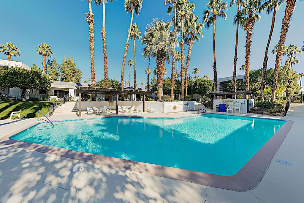 una piscina con palme sullo sfondo di Palm Tree Retreat Unit 128 Permit# 4330 a Palm Springs
