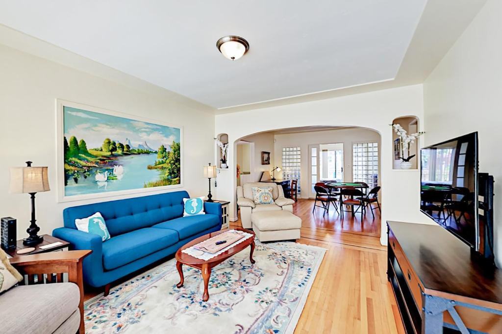sala de estar con sofá azul y mesa en Little Italy Charmer en San Diego