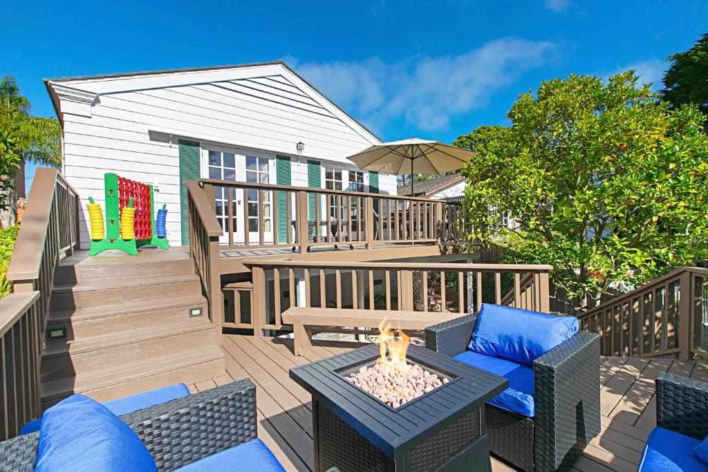a deck with a table and chairs and a fire pit at Ludington Palace in San Diego