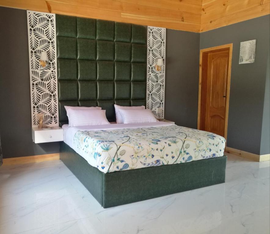 1 dormitorio con 1 cama con cabecero verde en Tourist Inn Hotel en Shogran